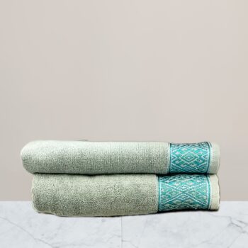 a stack of towels on a marble surface green towel 600 gsm towel