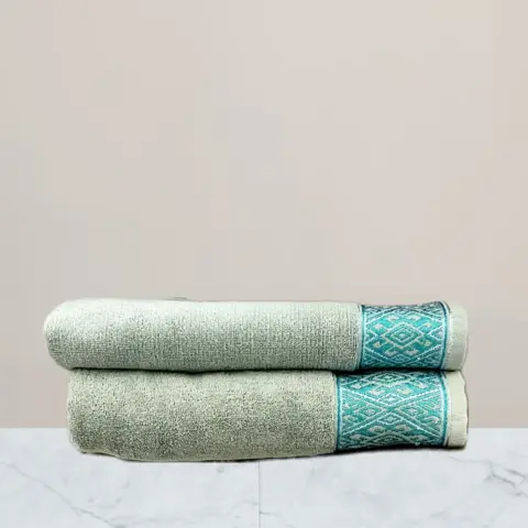 a stack of towels on a marble surface green towel 600 gsm towel